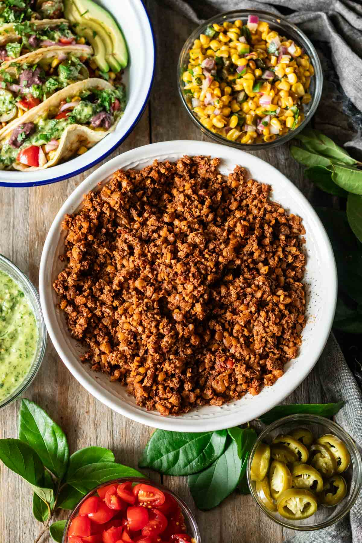 bowl of walnut taco meat with bowls of toppings.