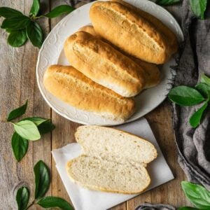 platter of hoagie rolls with one cut open and laid on a piece of parchment.