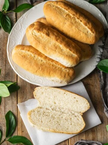 platter of hoagie rolls with one cut open and laid on a piece of parchment.