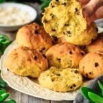 person holding half of a Cornish saffron bun with currants.