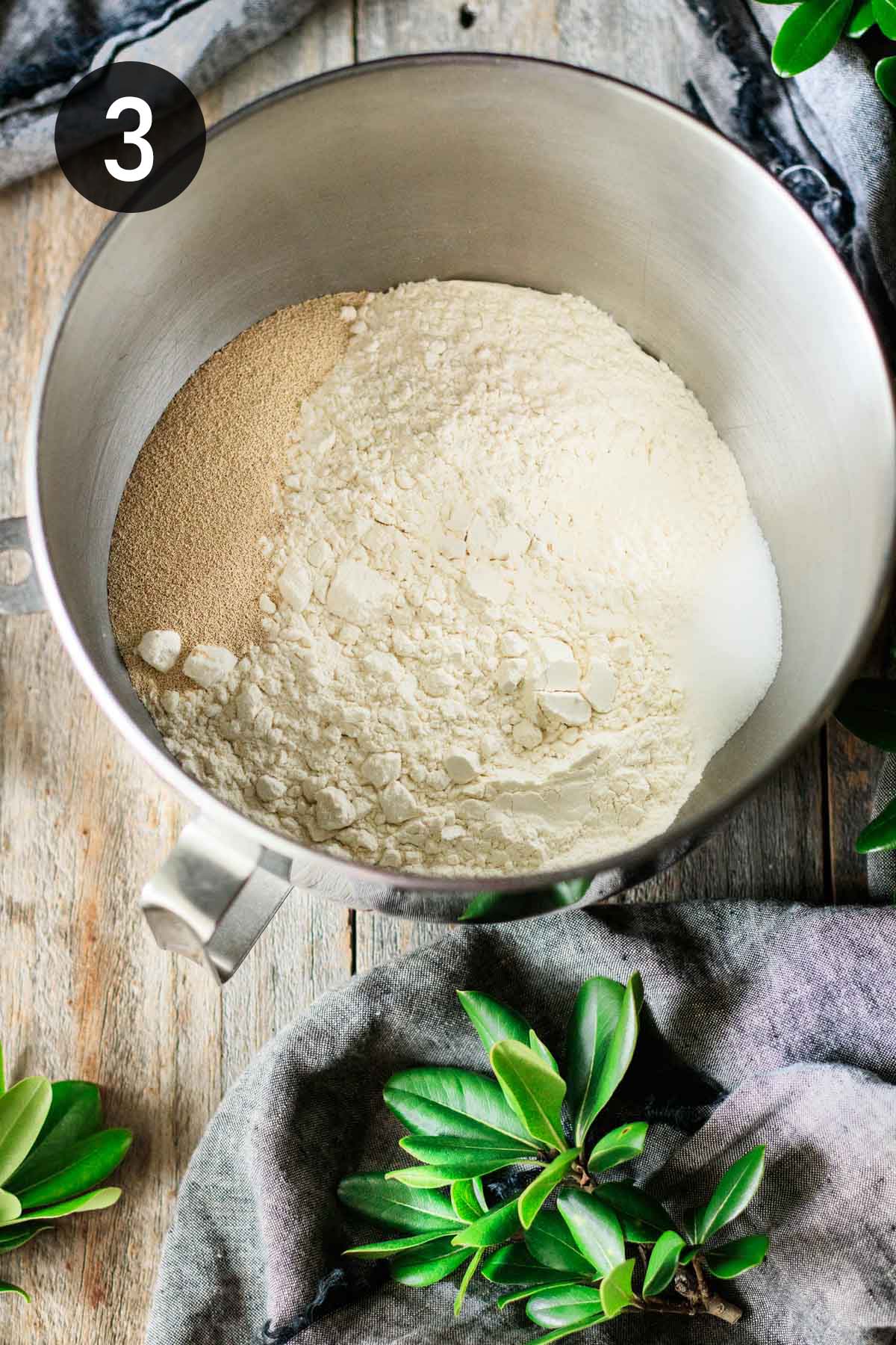 stirring yeast and salt into a bowl of bread flour.