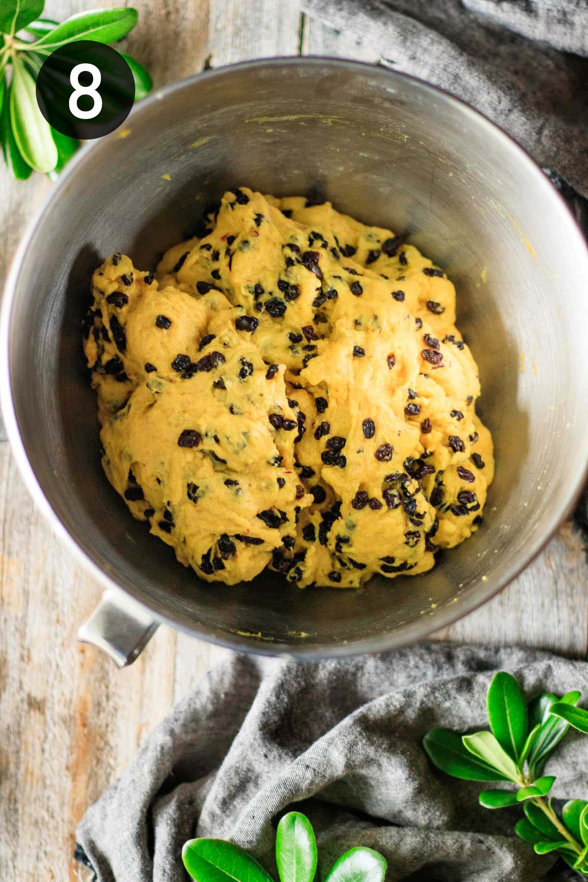 mixing dried currants into yellow dough.