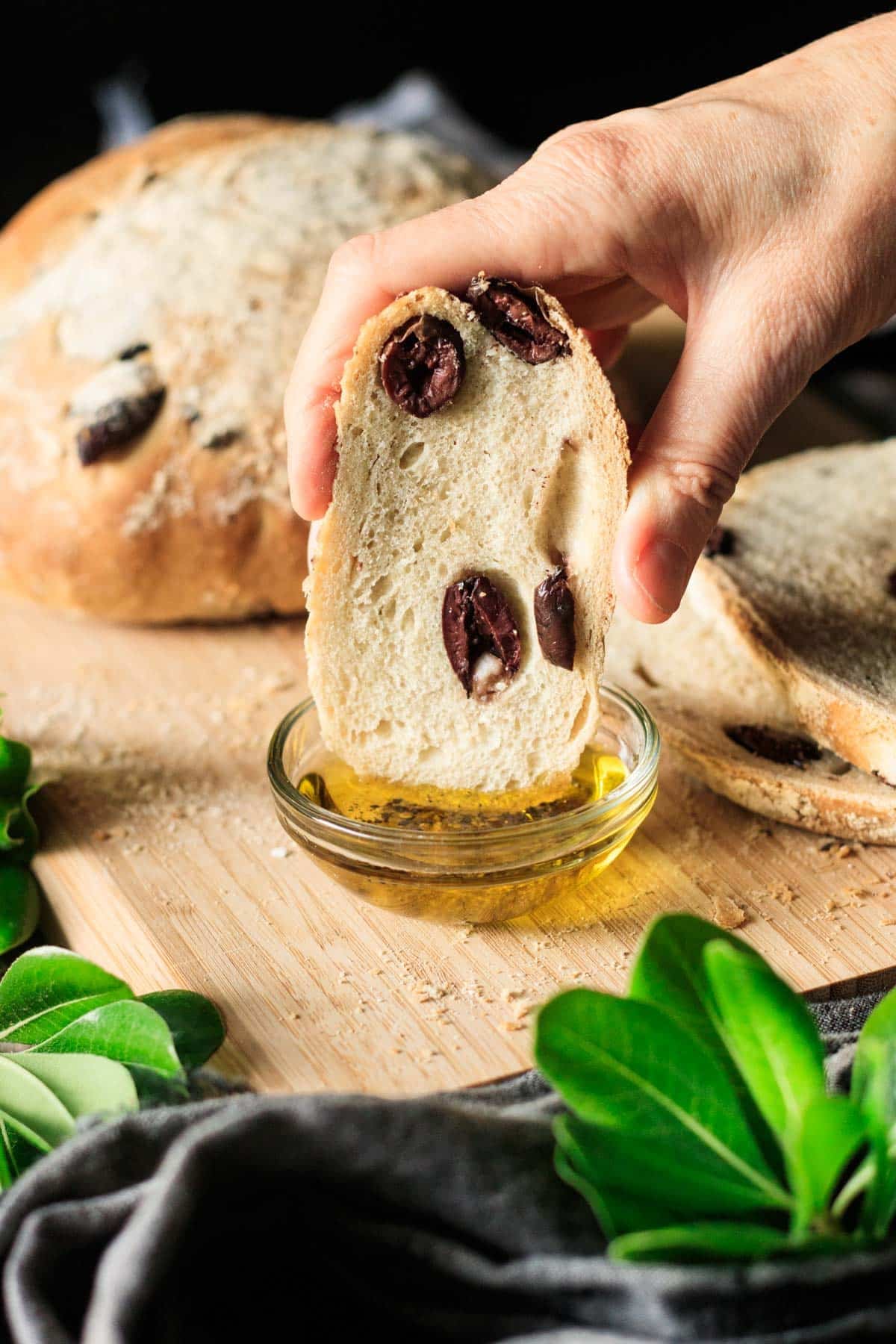 dipping a slice of olive bread into a dish of olive oil and black pepper.
