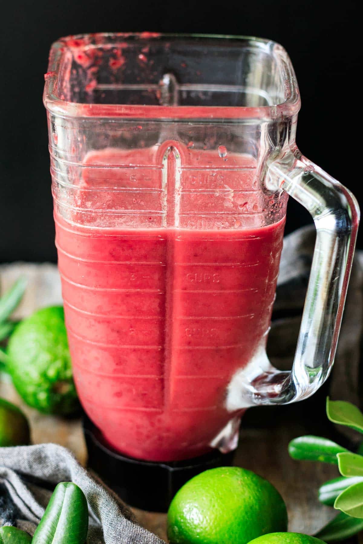 cherry limeade mixture in a glass blender with sparkling water added.