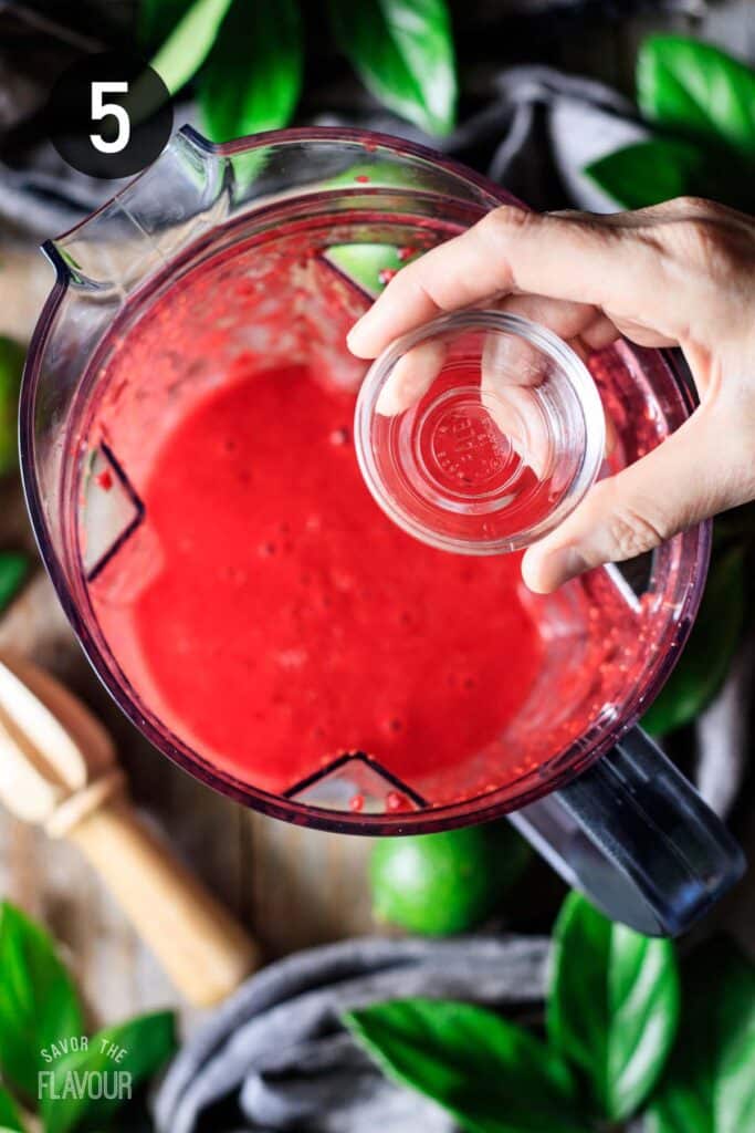 adding rum extract to the blender of daiquiri mixture.