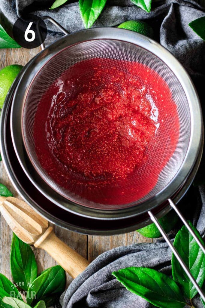 straining raspberry seeds out with a mesh sieve.