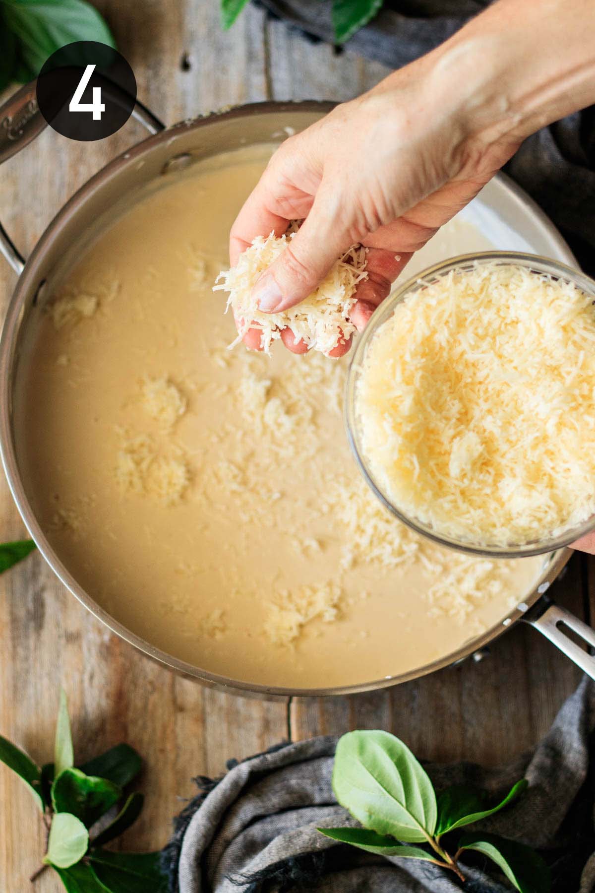 adding grated cheese to the white sauce.