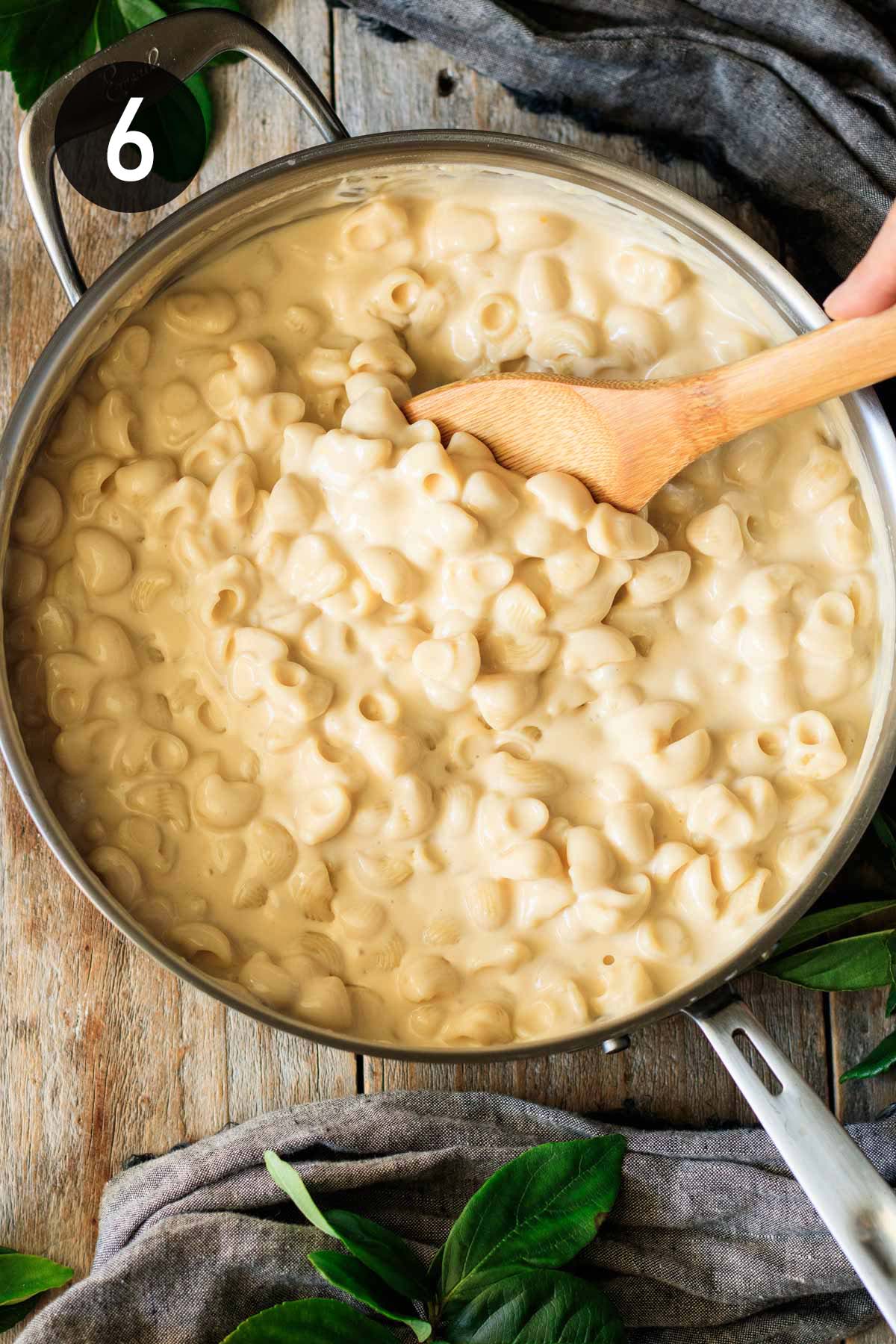 folding cooked pipette pasta into the cheese sauce.