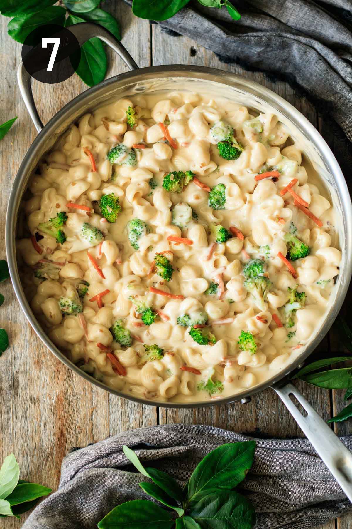 adding broccoli and carrots to the mac and cheese.
